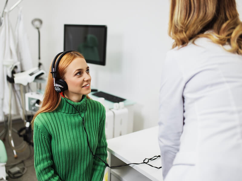 Woman getting a hearing aid discovery test to protect her hearing health.
