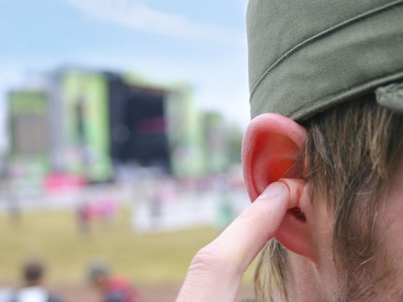 Man using earplugs to protect his hearing before a concert.
