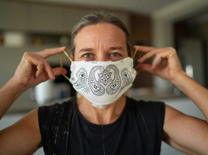 Women protects her hearing health by wearing a mask.
