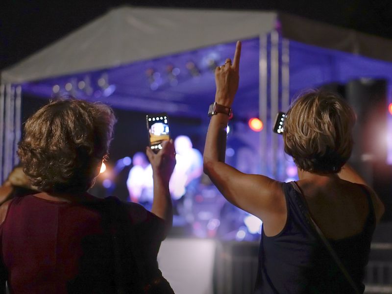 Women enjoying a summer concert with hearing protection.