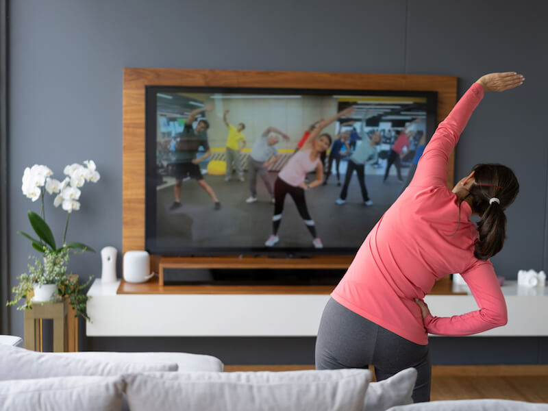 Woman concerned about her health working out to the television.