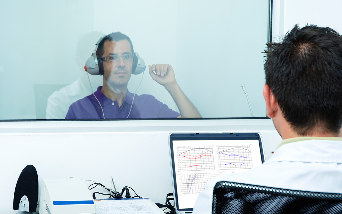 Man taking a hearing test in a booth.