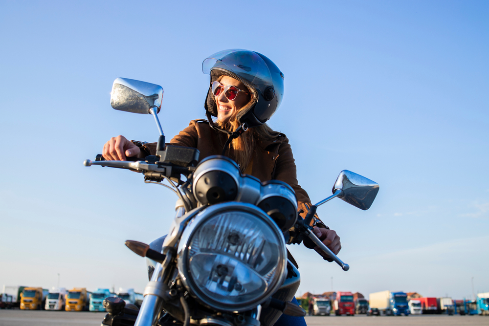 woman on motorcycle with helmet on.