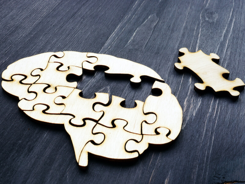 Wooden brain puzzle representing mental decline due to hearing loss.