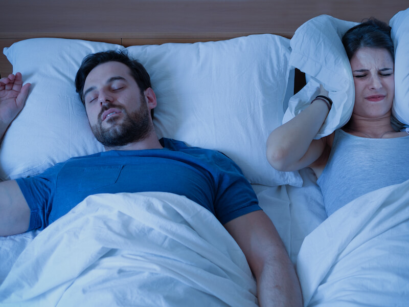 Man snoring keeping his partner awake because he has sleep apnea.
