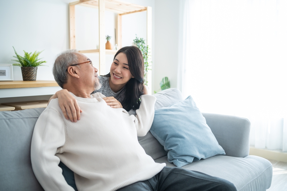 adult daughter greeting and hugging older father.