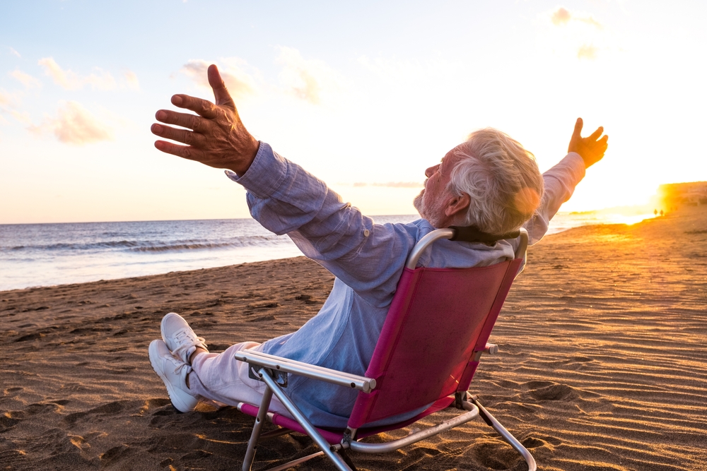 man at the beach feeling free with opened arms.